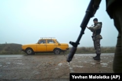 A car is stopped at a checkpoint manned by Ukrainian police officers in Berdyansk, on the coast of the Azov Sea, on November 27.