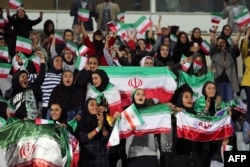 Iranian women cheer during the friendly between Iran and Bolivia at Azadi Stadium in Tehran on October 16.