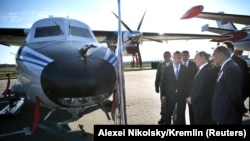 Russian President Vladimir Putin looks at a Let L-410 UVP-E20 Turbolet transport aircraft during a visit to Patriot military park outside Moscow in 2018. 