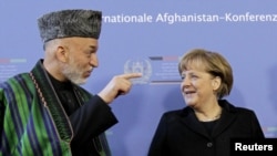 German Chancellor Angela Merkel (right) talks with Karzai in Bonn on December 5.