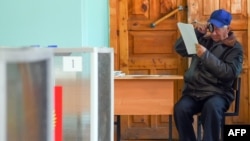 A voter inspects a ballot paper before voting in Russian regional elections at a polling station in the town of Kostroma, some 300 kilometers outside of Moscow, on September 13.