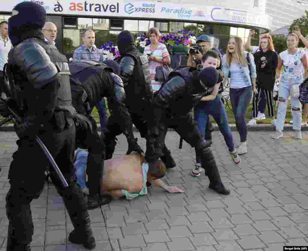 Security forces struggle with protesters in Minsk.