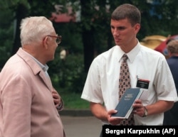 A young Mormon missionary from the United States speaks with an elderly Russian man in 1997.