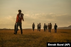 Young men who say they deserted the Afghan military and fled to Turkey through Iran walk in the countryside in Tatvan, Bitlis Province, in eastern Turkey, in August 2021.