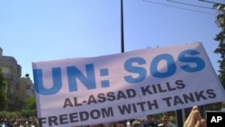 Antigovernment protesters carry a banner during a rally in the central Syrian city of Homs in early May.