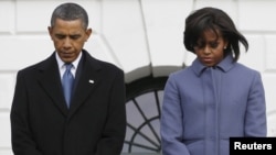 U.S. President Barack Obama and First Lady Michelle Obama take part in the moment of silence.