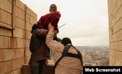 Islamic State militants prepare to throw a man from a high rooftop as punishment for allegedly being gay in Mosul.