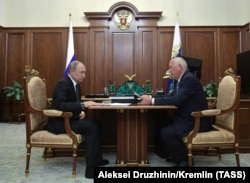 Russian President Vladimir Putin (left) meets with head of the Rostec state conglomerate, Sergei Chemezov, in Moscow in July 2019. Chemezov worked with Putin when both were KGB officers stationed in Dresden in the 1980s.