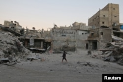 A boy walks amid damaged buildings in a devastated part of the Syrian city of Aleppo.