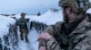 Ukrainian servicemen walk along a snow-covered trench at the front line near Vodiane in eastern Ukraine on March 5.