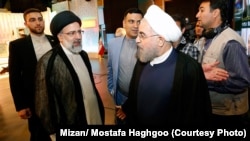 Iranian President Hassan Rohani (right) and Ebrahim Raisi speak just before the second presidential debate on May 5 in Tehran.