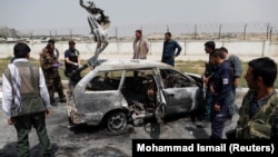 Afghan officials inspect a vehicle from which insurgents fired rockets in a deadly attack in Kabul on August 18.