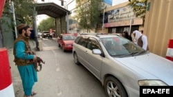 Taliban members check vehicles at the entrance to the Green Zone where most foreign embassies are situated in Kabul on August 22, days after the militant group seized control of the Afghan capital. 