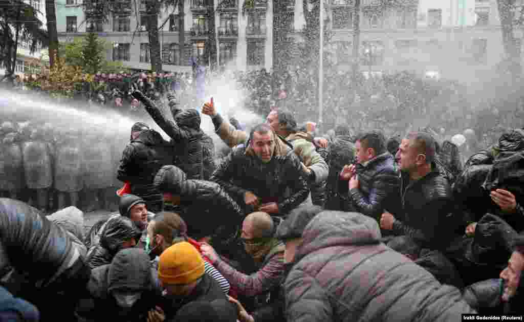 Riot police doused the protesters as they huddled in groups outside the parliament building.&nbsp;