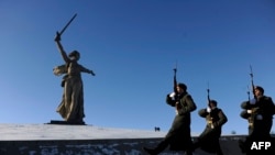 Honor guards march past the giant monument built to honor those who died in the World War II Battle of Stalingrad.