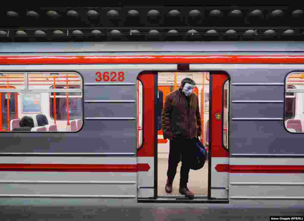 A man exits a subway car wearing a Guy Fawkes mask on March 17. The day before, Prague&#39;s mayor said on Twitter:&nbsp;&ldquo;On Prague public transport, it is mandatory to have a covered mouth and nose! Whether you have medical masks, self-made masks, or use a scarf, anything is better than nothing.&rdquo;&nbsp;