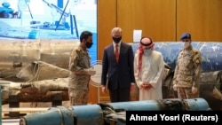 Saudi Arabia's Minister of State for Foreign Affairs Adel al-Jubeir (second from right) and U.S. Special Representative for Iran Brian Hook (second from left) inspect a display of the debris of ballistic missiles and weapons that the Saudis say were supplied by Iran to Huthi rebels in Yemen. 