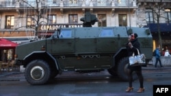 A woman walks past an armored personnel carrier in Brussels on November 23.