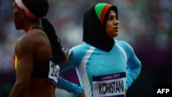 Afghanistan's Tahmina Kohistani (right) reacts after competing in the women's 100-meter heats at the athletics event during the London 2012 Olympic Games.