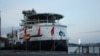 A specially designed ship with a helicopter pad prepares to take supplies from Stavanger harbor to an offshore oil platform.