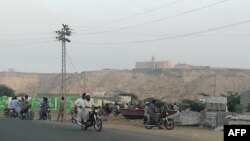 Locals look at the five-star Pearl Continental hotel, located on a hill in the southwestern Pakistani city of Gwadar, on May 11. 