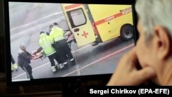 A person watches a video on social media showing Russian opposition leader Aleksei Navalny being carried on a stretcher by an ambulance team in Omsk on August 20.