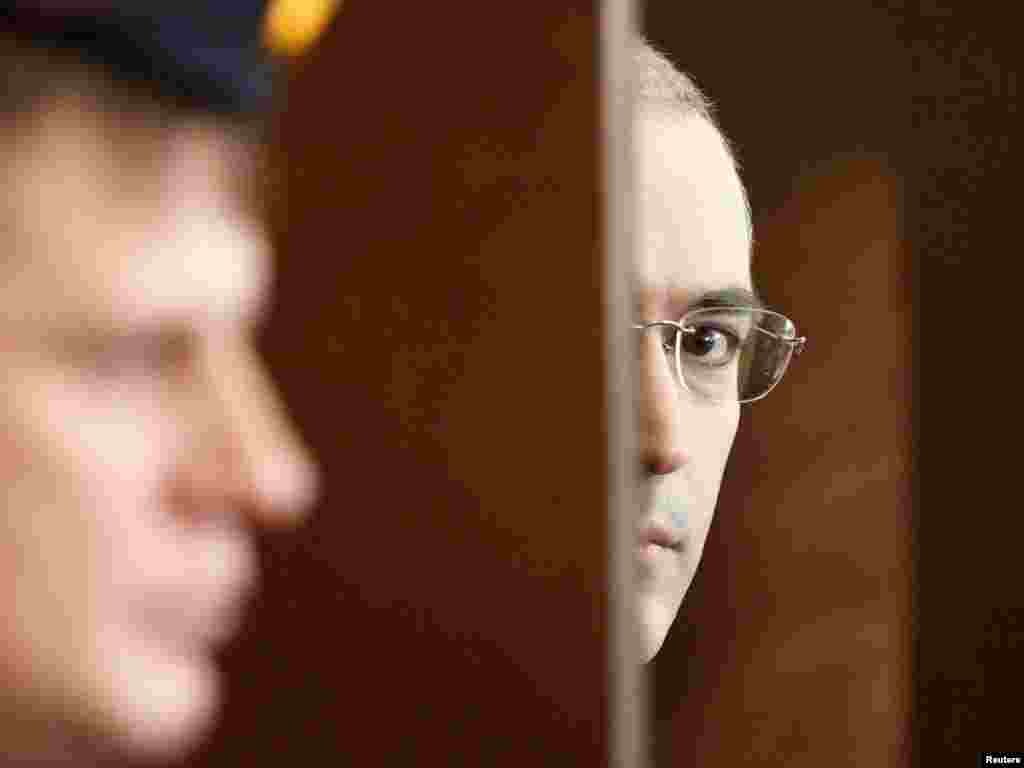 Looking out of the defendant's cage as he attends a court session in Moscow on October 19, 2010.