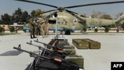 A U.S. soldier and Afghan National Army (ANA) soldiers at an exhibition of military equipment donated to the ANA by the United States and other countries at the Defense Ministry in Kabul in 2011.