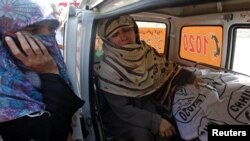 Rukhsana Bibi (center) weeps in an ambulance outside Jinnah Hospital in Karachi on December 18, next to the body of her slain daughter Madiha, who worked for an antipolio campaign.