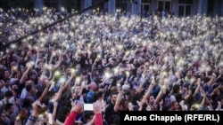 Protesters hold their phones aloft as Tbilisi protest leader Zaza Saralidze speaks to the crowd.