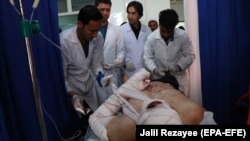 A man who was injured in a bombing targeting a vehicle carrying Hazara receives medical treatment in Herat on June 4, 2018.