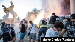 Demonstrators clash with police officers in front of the parliament building in Belgrade.