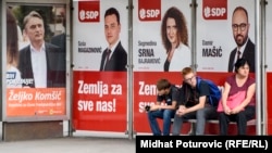 People wait at a bus stop draped in election posters in the Bosnia capital, Sarajevo, late last month. 