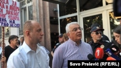 Montenegrin oppositionists Andrija Mandic (right) and Milan Knezevic meet with supporters as they arrive for a court hearing in Podgorica on July 20.