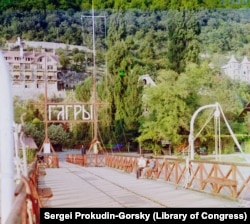 Boys wearing military caps squint into the evening sun as Prokudin-Gorsky works in Gagra.