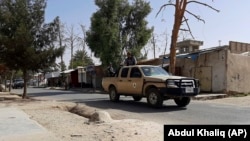 Afghan security personnel patrol a deserted street during fighting between the Taliban and Afghan security forces in Lashkar Gah on August 3.