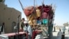 Afghan police check residents fleeing Marjah as they arrive in Lashkar Gah, in Helmand Province, on February 8.