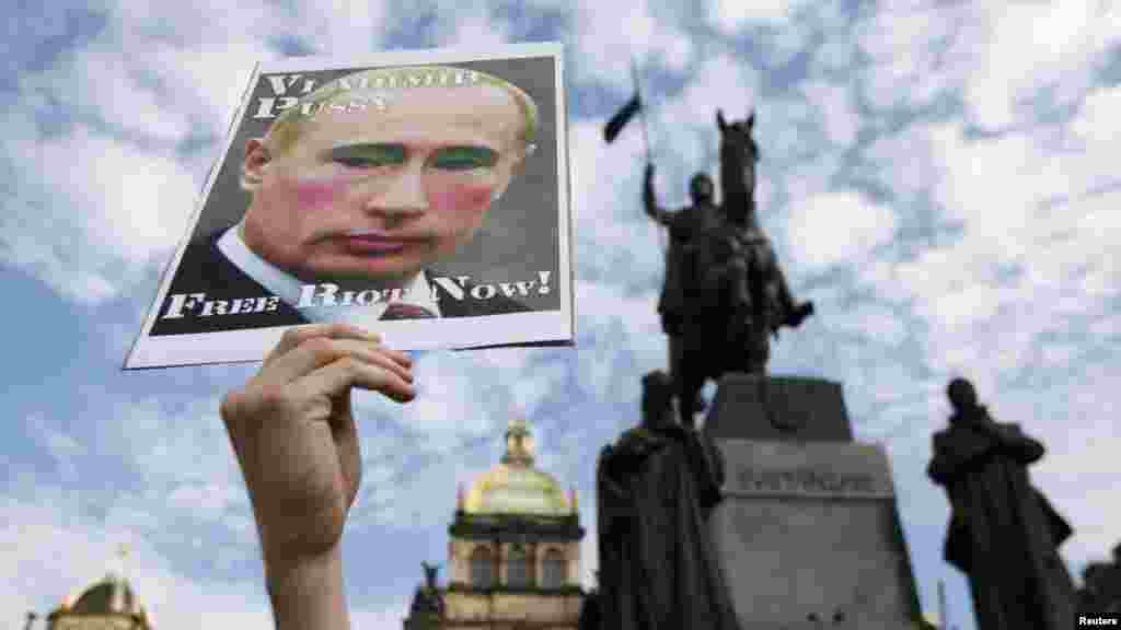 An activist holds up a poster depicting Russian President Vladimir Putin during a protest rally in support of Pussy Riot on Wenceslas Square in Prague.