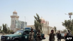 Afghan security forces stand guard in front of the mosque in Kandahar on July 14.