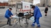 Ambulance workers transport an elderly woman -- with suspected coronavirus symptoms -- from a bus stop to a hospital in central Moscow on April 17.