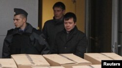 Detained opposition activist Konstantin Lebedev (right front) is escorted out of a building of the Russian Investigative Committee in Moscow on October 17.