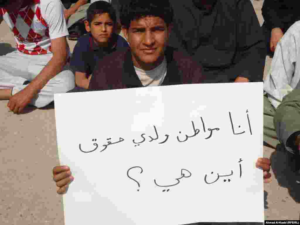 A protester in Amara, Misan province holds a sign that says, "I am a citizen and I have rights. Where are they?"