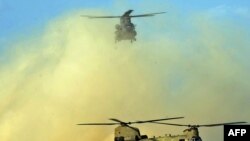 Two U.S. Chinook helicopters land at Kandahar airfield in March 2011.