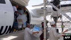 Independent Election Commission workers, overseen by Italian troops, unload ballot boxes flown in on a UN aircraft from Farah Province to be sent onward to Kabul, at Herat airport on July 24.