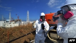 A journalist checks the radiation level with her dosimeter before the stricken Fukushima Daiichi nuclear power plant in Fukushima Prefecture on February 28.