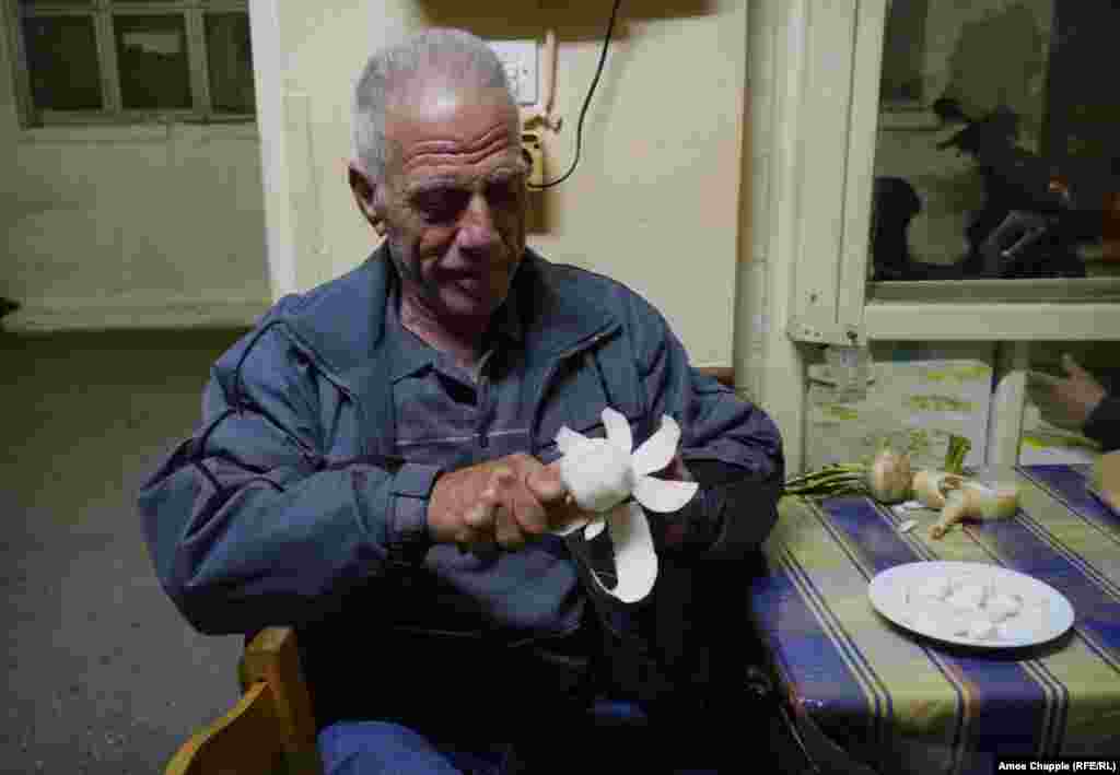 Retired builder&nbsp;Giorgos&nbsp;Kolaras&nbsp;peels a turnip at the doorway to the&nbsp;taverna.