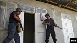 Police prepare to enter a home in an Uzbek district of Osh on June 22.