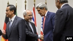 Iranian Foreign Minister Mohammad Javad Zarif (second from left) shakes hands with U.S. Secretary of State John Kerry as Chinese Foreign Minister Wang Yi (far left) and French Foreign Minister Laurent Fabius (far right) mark the nuclear deal in Geneva early on November 24.