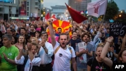 Protesters shout slogans in front of the parliament building in Skopje on April 18.