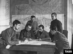 Bolshevik military commanders "discuss the suppression of the Kronstadt rebellion." A map of the island fortress can be seen in the background.